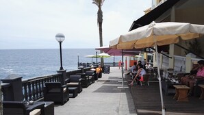 An outdoor seating area with tables and chairs, overlooking the sea. - Luxury Bungalow Costa Adeje; Heated Pool, Air Conditioner, WiFi & Parking free (Adeje)