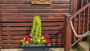 A wooden sign with the text "Bendin the River Lodge no. 94" and a flower planter in front of it.