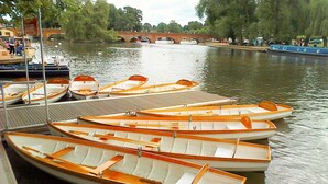 A row of wooden rowboats docked at a pier.