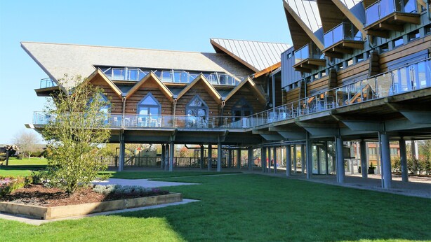A modern building with a unique architectural design, featuring multiple balconies and large windows.