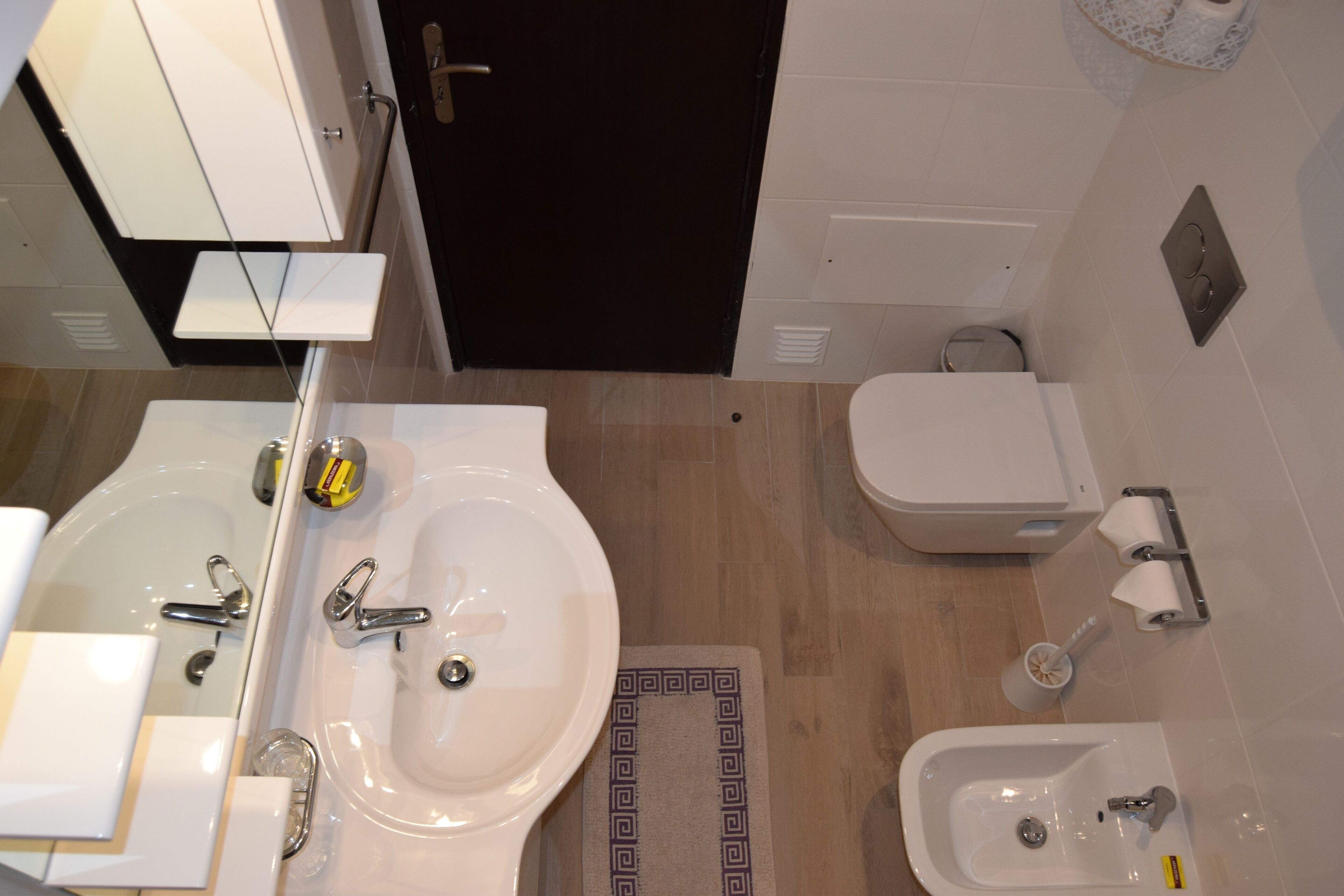 A modern bathroom with a sink, bidet, toilet, and bidet seat.