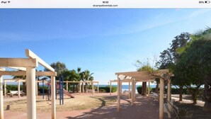 Une aire de jeux avec des structures en bois et un chemin pavé de briques.