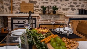 A stone wall, wooden table, and a fireplace with a brick mantle. - Villa Miandri with heated pool (Debeljak)