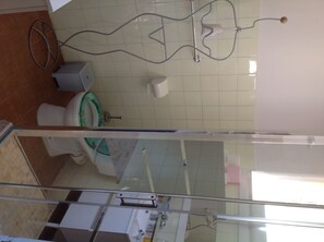 A bathroom with a toilet, bidet, and a glass shower enclosure. - Charming studio with sea view (Hyères)