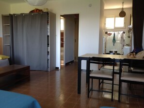 Um espaço compacto com área de refeições, cozinha compacta e um espaço de dormir separado.