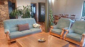 A living room with a sofa, two armchairs, a coffee table, and a stone wall. - Fantastic rural house "Amaltea" in Candeleda (Candeleda)