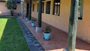 A building with a covered patio area, stone columns, potted plants, and a clear sky. - Fantastic rural house "Amaltea" in Candeleda (Candeleda)