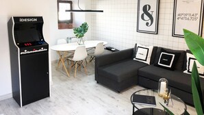 A modern hotel lobby with a black iDESIGN kiosk, a round dining table with chairs, a grey sofa, and framed artwork on the walls. - BEAUTIFUL DESIGN FLOOR IN THE CENTER OF AVILA FOR 6 PEOPLE (Ávila)