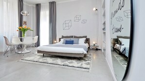Un dormitorio moderno con cama, mesitas de noche, un escritorio y una silla.