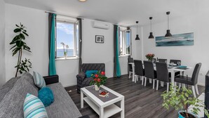 Una sala de estar moderna con sofá, mesa de centro y comedor.