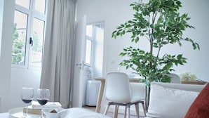 A cozy room with a bed, a dining table, and a potted plant. - Ribeira Funchal Center (Funchal)