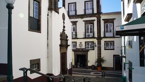 A narrow street with white buildings, a staircase, and a lamppost. - Ribeira Funchal Center (Funchal)