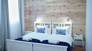 A double bed with white headboard and two bedside tables, one with a lamp. - Ribeira Funchal Center (Funchal)