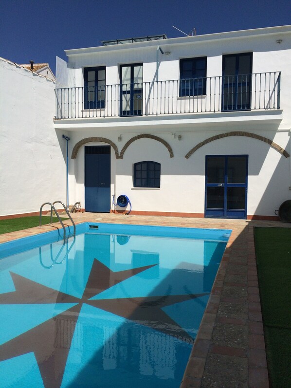 A two-story building with a swimming pool in front.