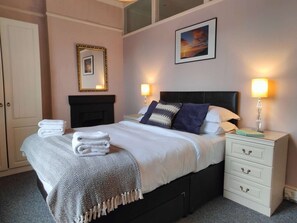 Relax in comfort with a large bed, bedside tables, and a fireplace.