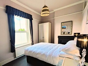 Cozy retreat with a large bed, window, and wardrobe.