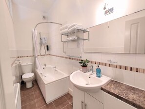 Bathroom features a separate shower area, bathtub, and toilet, along with a vanity and sink.