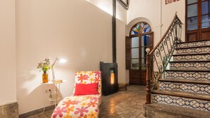 A cozy room with a bed, a small table with a lamp, and a fireplace. - Mlle. BIBI Casa Tipica Soller in center of Soller. Parking at 500m included.  (Sóller)