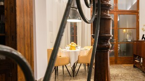 A dining area with a table set for four, a wooden staircase, and a view through a glass door. - Mlle. BIBI Casa Tipica Soller in center of Soller. Parking at 500m included.  (Sóller)