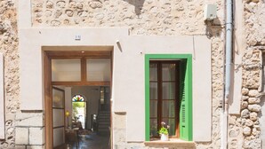 A stone building with a wooden door and a window with green shutters. - Mlle. BIBI Casa Tipica Soller in center of Soller. Parking at 500m included.  (Sóller)