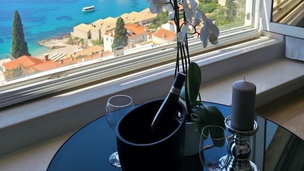 Un balcon avec une table, une bougie et un vase de fleurs.