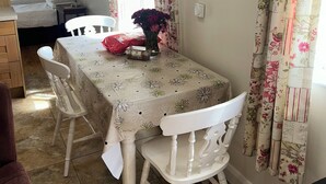 Un coin repas avec une table, des chaises et un vase de fleurs.