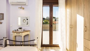 Quarto com cama, mesa de cabeceira com espelho, guarda-roupa e ar condicionado.