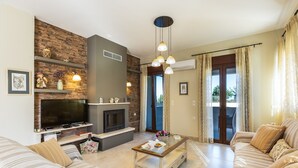 Uma sala de estar moderna com lareira, televisão, sofá e mesa de centro.