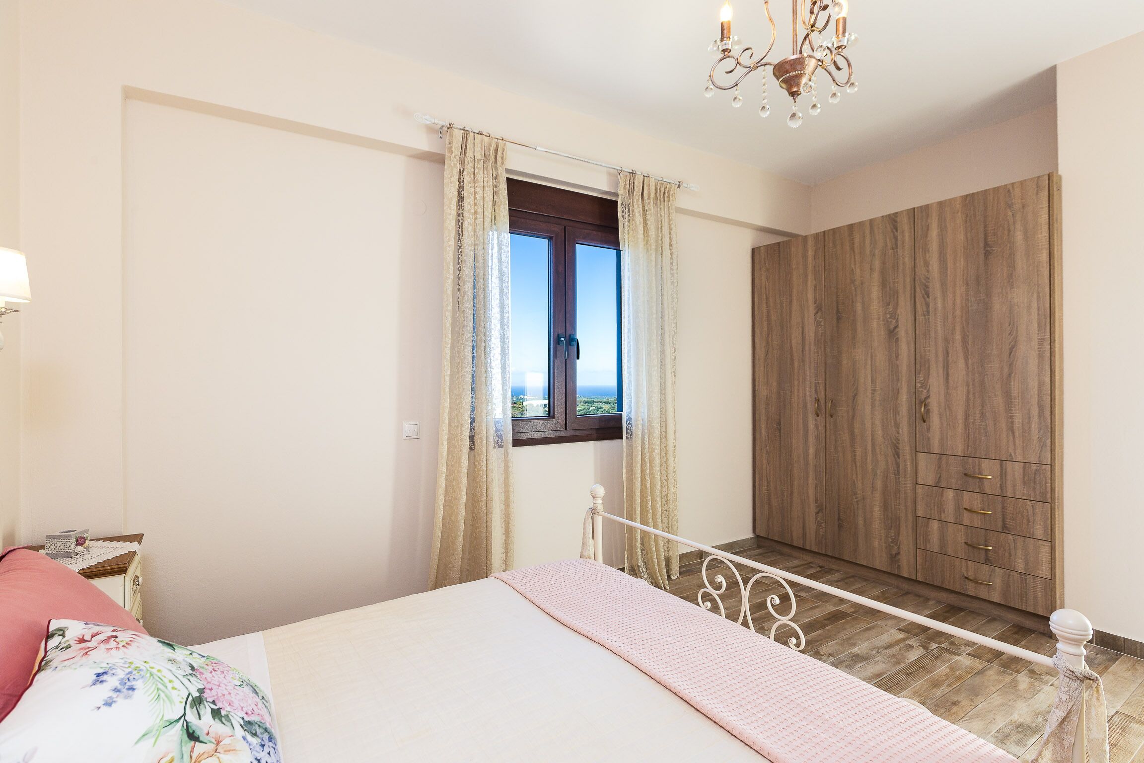 A bedroom with a bed, a wardrobe, and a window with curtains.