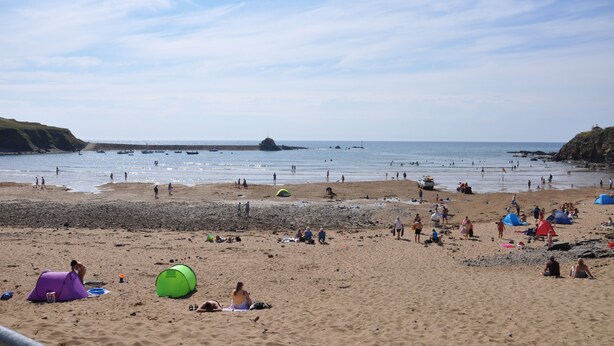Una spiaggia con tende e persone.