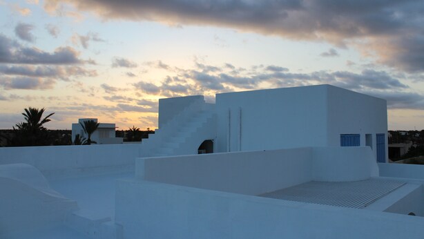 A white building with a flat roof and a small window.