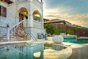A stone building with a pool, a wooden fence, and a wooden deck. - Fairytale Villa, in the heart of Lefkas town and Agios Ioannis beach! (Lefkada)