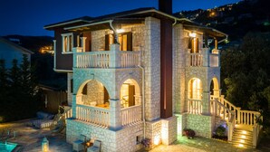 A two-story stone house with balconies, a swimming pool, and a well-lit outdoor area. - Fairytale Villa, in the heart of Lefkas town and Agios Ioannis beach! (Lefkada)