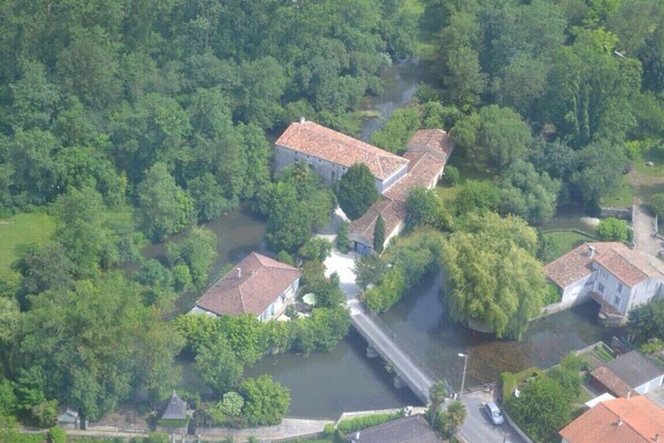 Surrounded by lush greenery, this riverside village features traditional architecture with red-tiled roofs and a tranquil waterway.