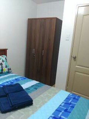Une chambre à coucher avec un lit, une armoire et une porte.