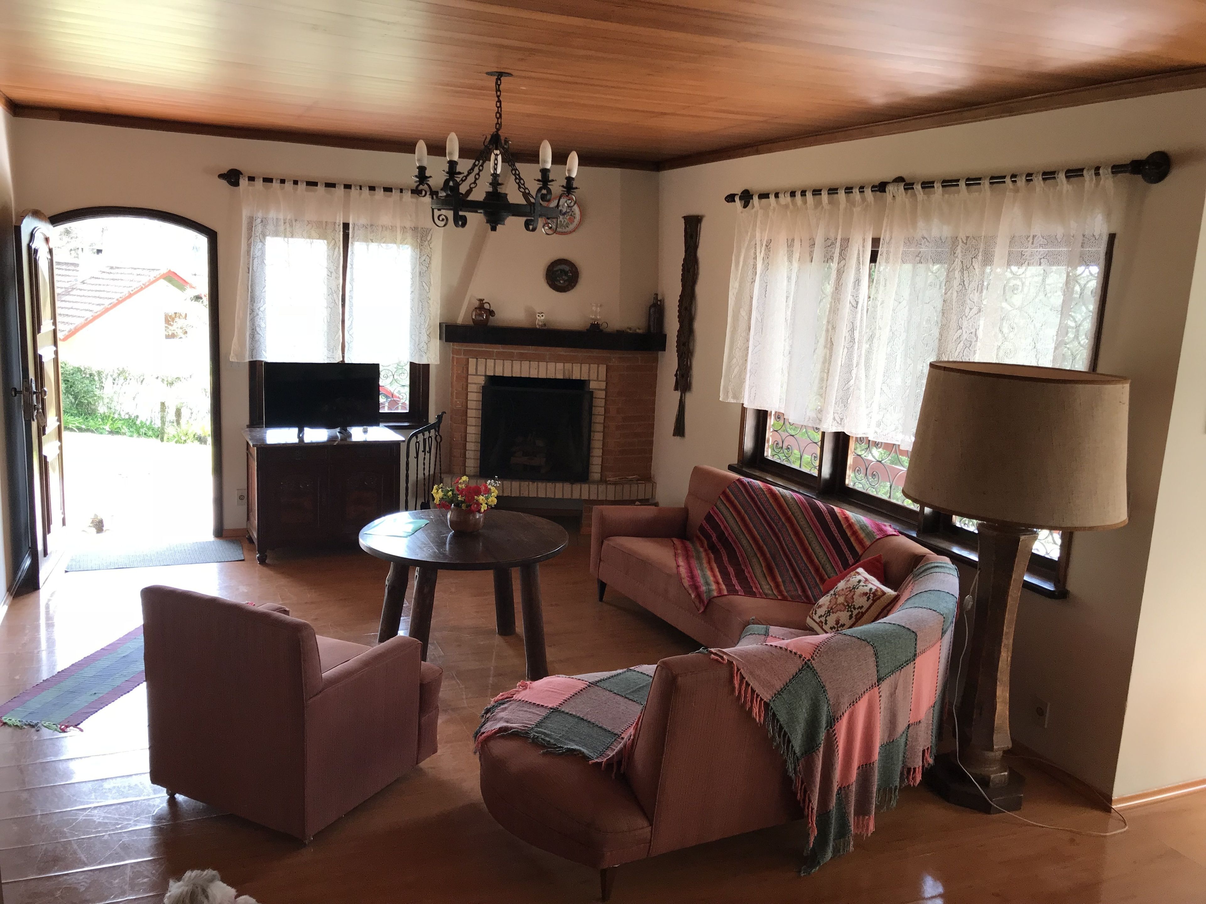 A cozy living room with a fireplace, a sofa, a coffee table, and a TV.