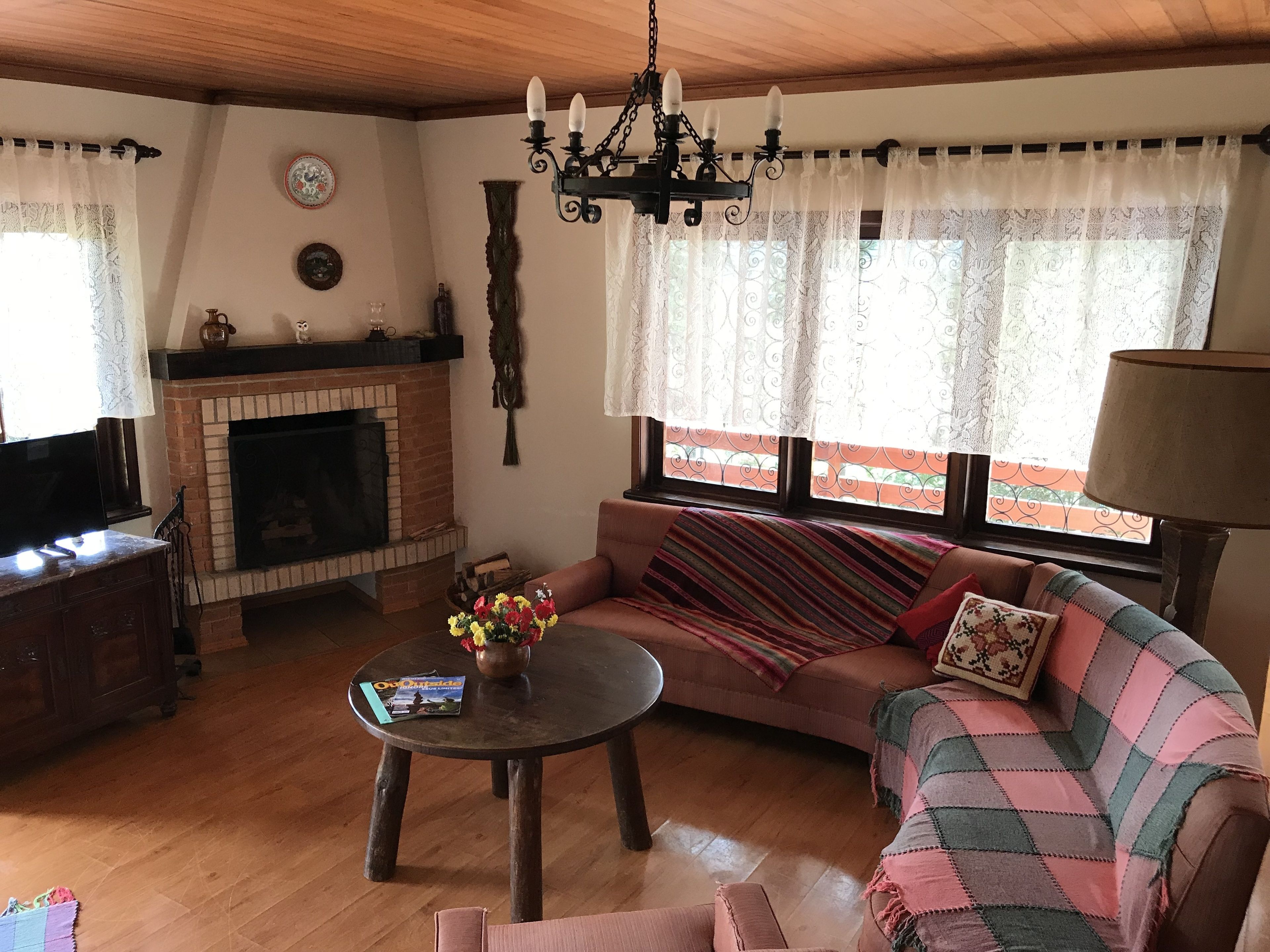 Una sala de estar acogedora con chimenea, un sofá, una mesa de centro y un televisor.