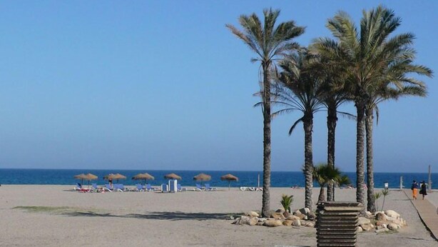 A beach with palm trees, sun loungers, and a clear sky. - Ground Floor Apartment in Palomares with Communal Pool (Palomares Almeria)