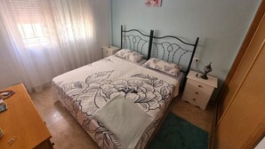 A bedroom with a bed, nightstands, a dresser, and a window with curtains. - Ground Floor Apartment in Palomares with Communal Pool (Palomares Almeria)