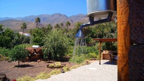 A garden with a water feature, palm trees, and a mountainous backdrop. - Rural House La Fuente de la Flora (Valle, El (Santa Lucia De Tirajana))