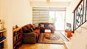 A living room with a sofa, a coffee table, and a bookshelf.