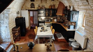 A cozy attic kitchen with stone walls, a dining table, and various kitchen appliances. - House / Villa - PONTCIRQ (Pontcirq)