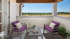 A balcony with two chairs, a table, and a potted plant. - Villa Meli in Vodnjan (Vodnjan)