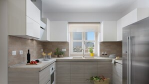 A modern kitchen with a large window, stainless steel appliances, and a wooden countertop. - Villa Meli in Vodnjan (Vodnjan)