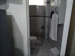 Regadera, secadora de cabello, toallas, papel de baño 