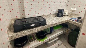A compact kitchen with a gas stove, a coffee maker, and a sink. - Oasis of Tolú, studio apartment 108 (Tolú)
