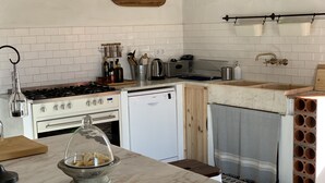 A kitchen with a stove, oven, dishwasher, and a wooden cabinet.