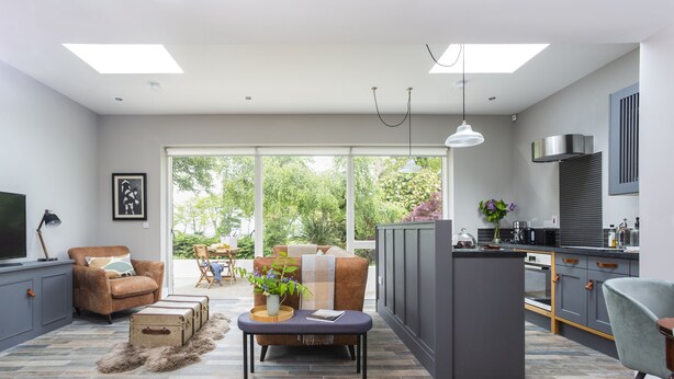 A modern living room with a sofa, coffee table, and a view of the outdoors. - The Garden Rooms @ Drumagosker Rural Retreats (Limavady)