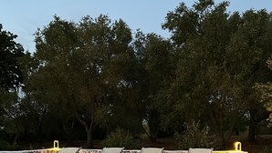 A swimming pool with lounge chairs and a stone wall. - Trullo holiday house Apulia with above ground pool (Ceglie Messapica)