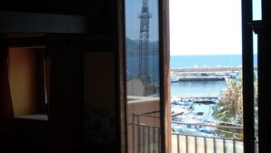 Ein Balkon mit Blick auf einen Yachthafen, inklusive Boote und einem entfernten Turm.